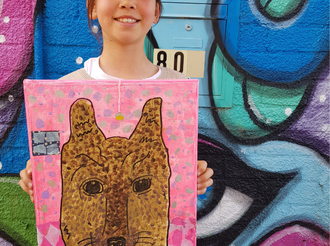 Child smiling with their artwork